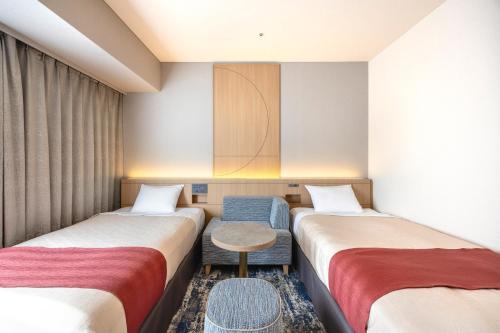 a hotel room with two beds and a table at Tokyo Bay Ariake Washington Hotel in Tokyo