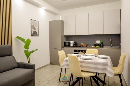 a dining room with a table and chairs in a kitchen at Coho House Fiumicino in Fiumicino