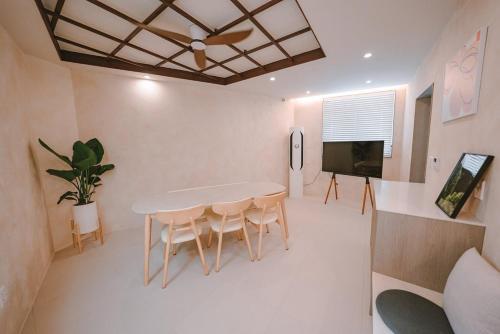 a dining room with a table and chairs and a tv at Jeonju One Two Stay in Jeonju