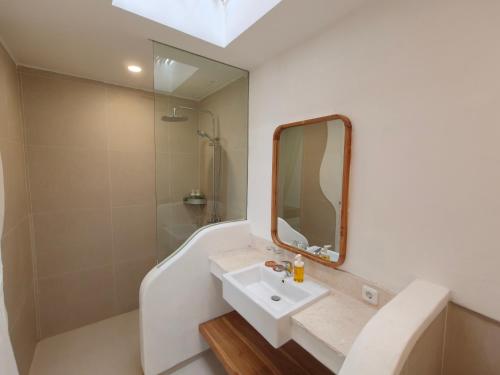 a bathroom with a sink and a mirror at Villa Melody Uluwatu by LODGELINK BALI in Badung