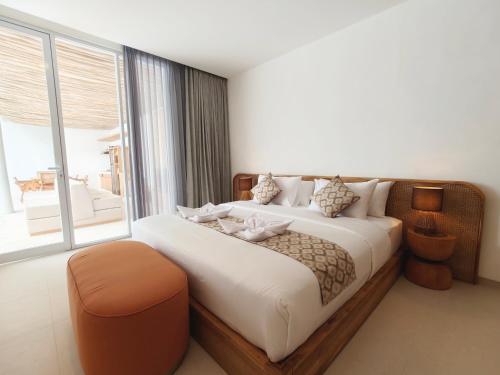 a bedroom with a large bed with a large window at Villa Melody Uluwatu by LODGELINK BALI in Badung