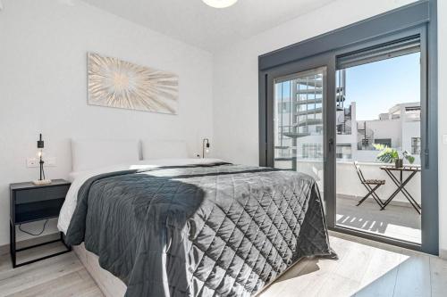 a bedroom with a bed and a large window at EG5.4A - Luxury Penthouse with Private Sun Terrace in Estepona