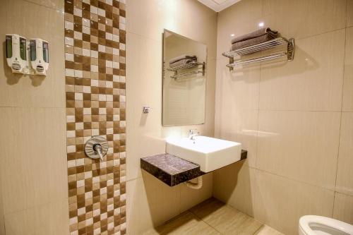 a bathroom with a sink and a toilet at Akasia Budget Hotel in Ulujami