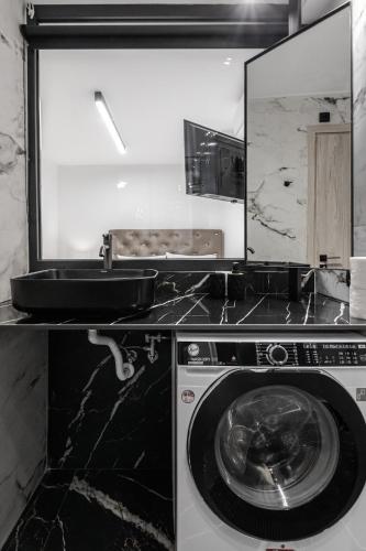 a kitchen with a washing machine and a mirror at Signature Luxury Loft in Volos