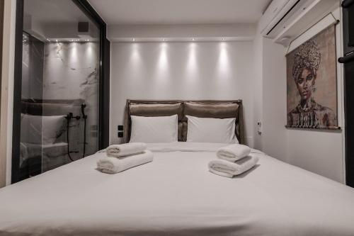 a bedroom with a bed with two towels on it at Signature Luxury Loft in Volos