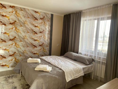 a bedroom with a bed with a stone wall at Green apple in Almaty