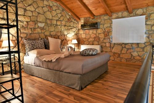 a bedroom with a bed in a stone wall at Messinian Horizons in Marathopoli