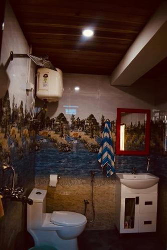 a bathroom with a toilet and a painting on the wall at Bungbakha Homestay in Singtām