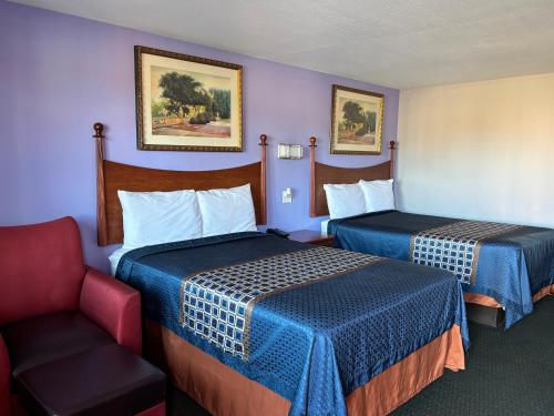 a hotel room with two beds and a chair at Royal Inn Linden in Linden