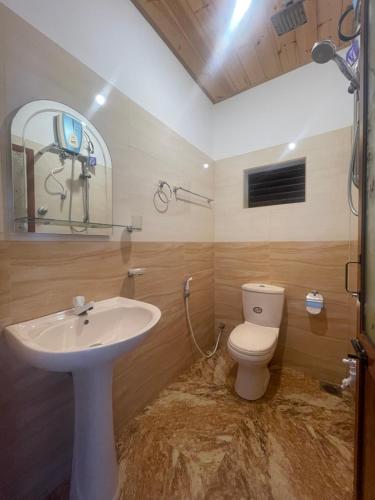 a bathroom with a white sink and a toilet at Saman Beach Guest House in Galle
