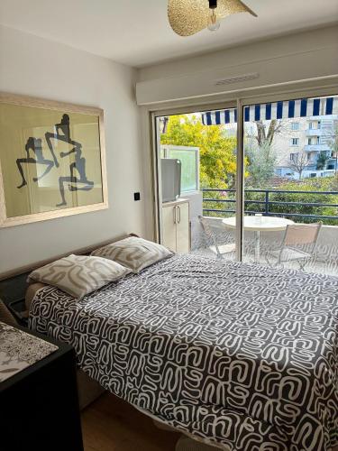 a bedroom with a bed and a sliding glass door at Studio cuisine parking piscine à Cannes in Cannes