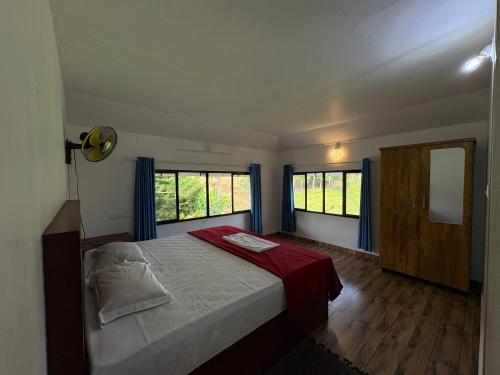 a bedroom with a bed and two windows at FroZen NeST in Vagamon