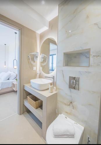 a white bathroom with a sink and a toilet at Suel Suites Afitos in Afitos