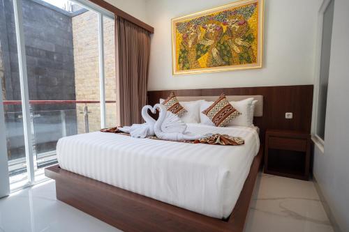 a bedroom with two swans sitting on a bed at Lumbung Sari Studio in Ngurah Rai International Airport