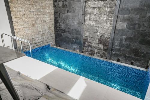 a bathroom with a shower with a blue swimming pool at Lumbung Sari Studio in Ngurah Rai International Airport