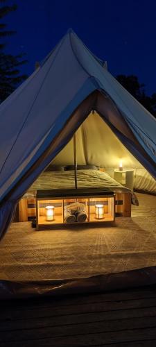 a tent with a bed with lights in it at ILLU Glamping in Trebujeni