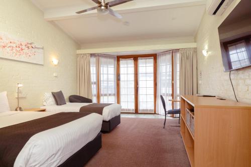 a hotel room with two beds and a television at Barclay Motor Inn in Devonport