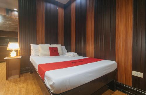 a bedroom with a large bed with a red blanket at RedDoorz Plus at Canley Residential in Manila