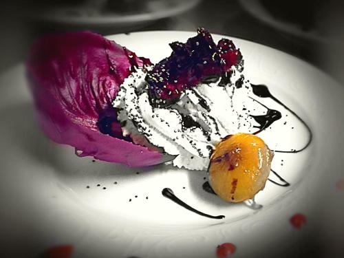 a piece of dessert on a white plate with an orange at Baita La Jolie Bergere in La Salle