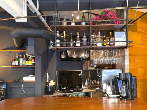 a bar with bottles and glasses on a wall at STAY WORK ASAKUSA guest house 浅草店 in Tokyo