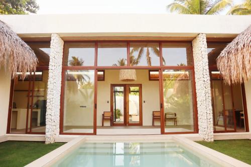 a house with a pool in front of it at Baiana Beach Villas in General Luna