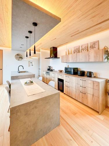 a large kitchen with wooden cabinets and a large island at Wa no ka in Koga
