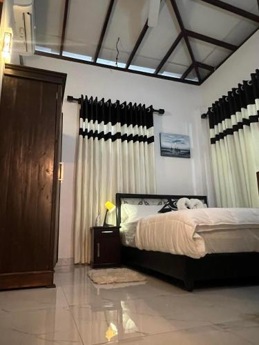 a bedroom with a bed and curtains in it at Cactus Boralesgamuwa in Boralesgamuwa