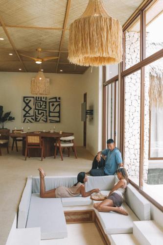 a group of people sitting on a couch in a living room at Baiana Beach Villas in General Luna