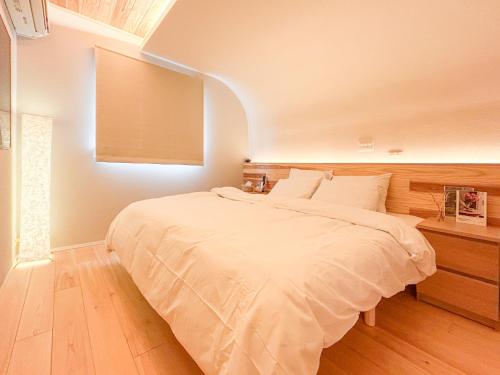 a bedroom with a large white bed in a room at Wa no ka in Koga