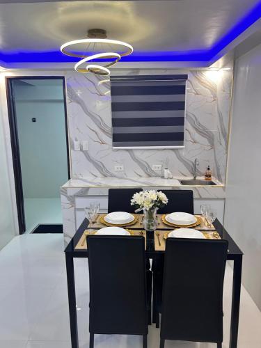 a dining room with a black table and chairs at DG Luxe Suites - Cabanatuan in Bangad