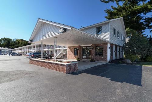 a building with a car parked in a parking lot at MOTEL 6 - Albany, NY - Airport in Albany