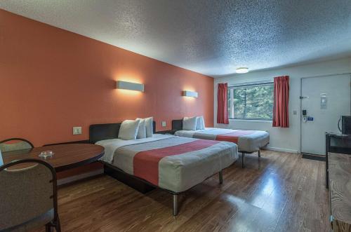 a hotel room with two beds and a table at MOTEL 6 - Albany, NY - Airport in Albany