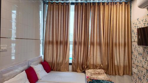a bedroom with a window with curtains and a bed at Hotel kingspalace and Dormitory in Vapi