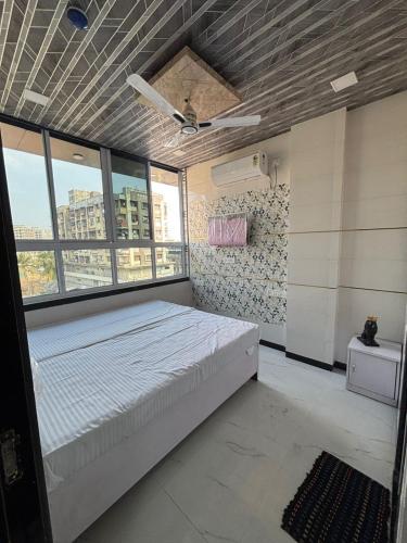 a bedroom with a bed in a room with windows at Hotel kingspalace and Dormitory in Vapi