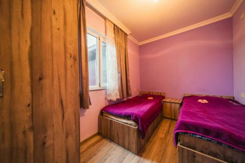 two beds in a room with purple sheets at Forest in Khulo