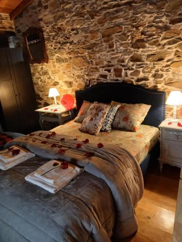 un letto in una stanza con un muro di pietra di Ceira Cottage Refúgio Romântico com Tanque Privado a Góis