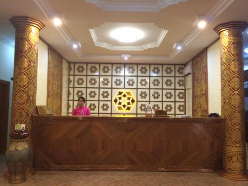a woman sitting at a reception desk in a hotel lobby at The Hotel Umbra Bagan in Bagan
