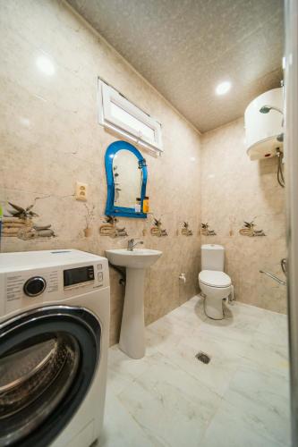 a bathroom with a washing machine and a sink at Forest in Khulo
