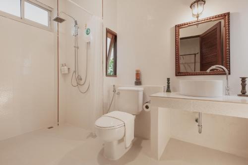 a bathroom with a toilet and a sink and a mirror at Foresta Villa in Hang Dong