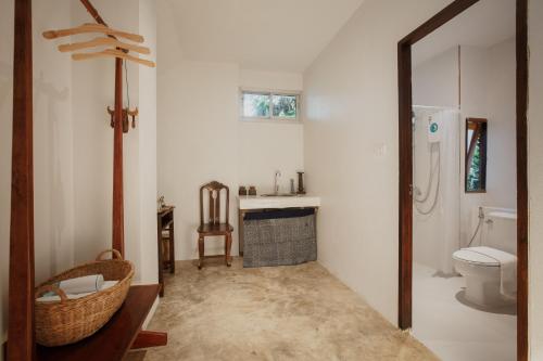a bathroom with a toilet and a sink and a mirror at Foresta Villa in Hang Dong