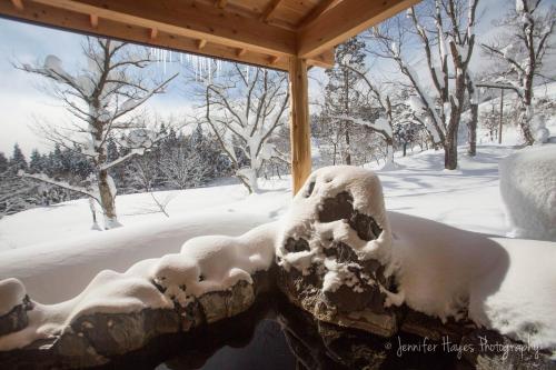 a statue covered in snow under a gazebo at Morino Lodge - Myoko in Myoko