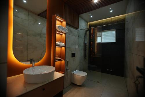 a bathroom with a sink and a shower and a toilet at Ymoon Mountain Resort Wayanad in Koroth