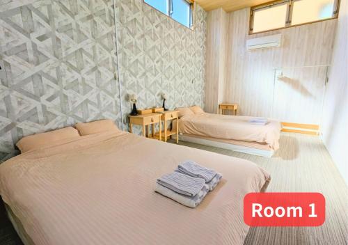 a bedroom with two beds and a room with room at MORIHIRO Building in Ichikawa