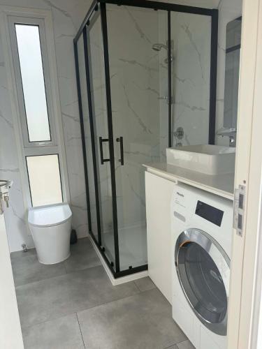 a bathroom with a washing machine and a sink at Country Charm Cabins 2 Bedroom Tiny Home in Coolabunia
