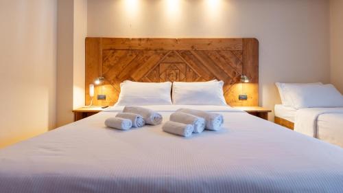a bedroom with a white bed with towels on it at Hotel Oasi in San Vito di Cadore