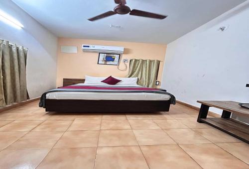 a bedroom with a bed with a ceiling fan at Hotel O Kurnool Railway Station Road in Kurnool