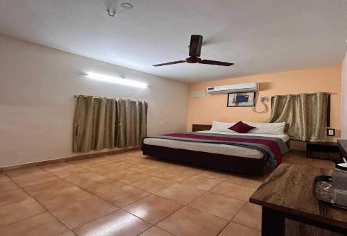 a bedroom with a bed and a ceiling fan at Hotel O Kurnool Railway Station Road in Kurnool