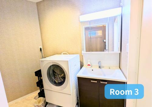 a bathroom with a washing machine and a sink at MORIHIRO Building in Ichikawa
