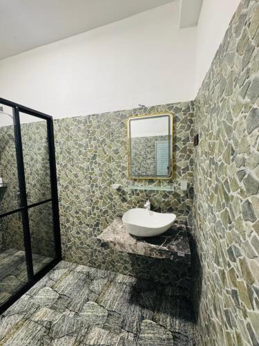 a bathroom with a sink and a mirror on a wall at Oasis Peak Ella in Ella