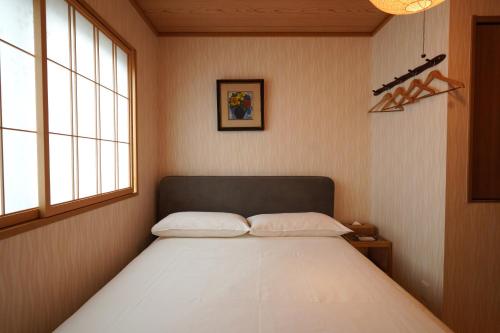 a bedroom with a bed in a room with windows at Shirakabanoyado - HOUKA 白樺の宿 - 芳華, Direct access to Umeda, Tsutenkaku, Tennoji in Osaka